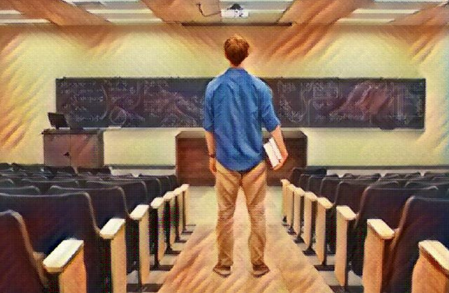Student standing alone looking at a chalkboard in a lecture all